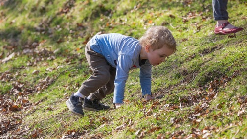 Close-up of a toddler climbing a slope